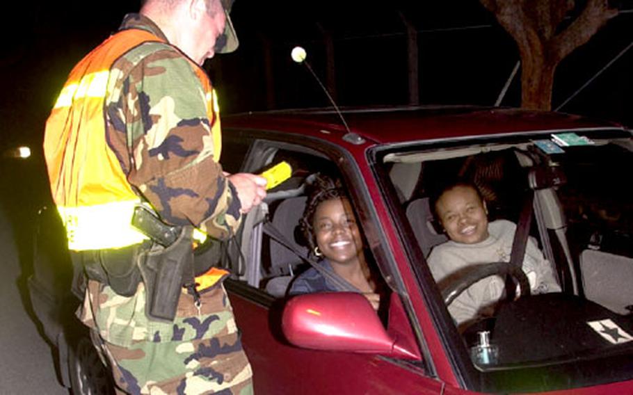 Marine military police stop cars at a sobriety checkpoint at Camp Lester, Okinawa. MPs have stepped up random checks of cars going both on and off base to curb drunken driving. The checks will continue past the New Year holiday, military police said.