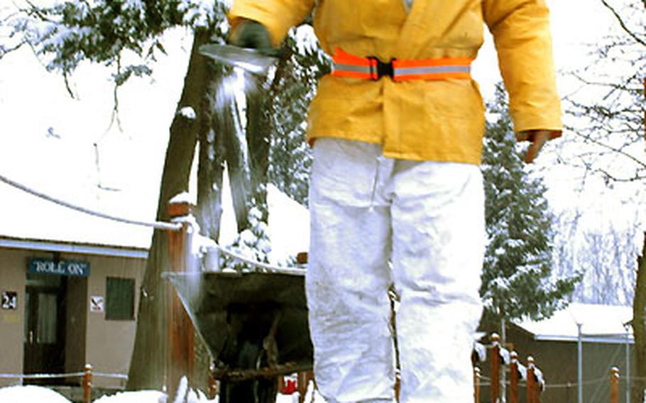 Smail Mazic of Brown and Root throws salt on Eagle Base sidewalks so people won’t slip.