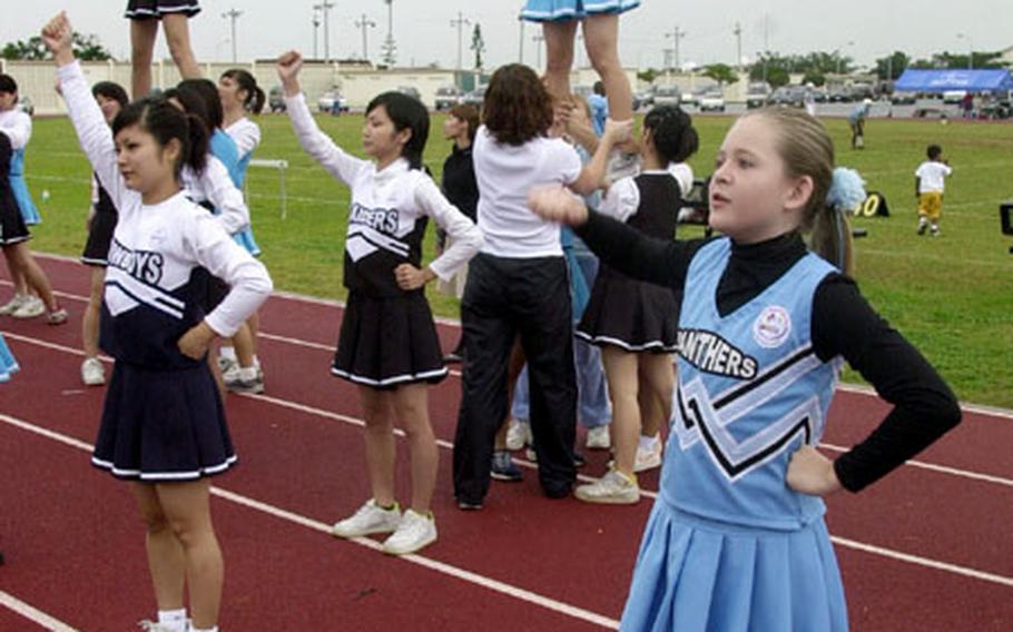 Cheerleaders from Kadena Youth Sports and Japanese girls from outside Kadena Air Base join together for first-of-its' kind cheerleading exchange during a football game Saturday on base.