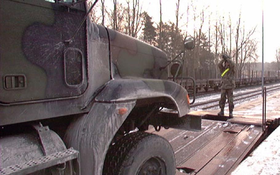 A soldier guides a 94th Engineer Battalion vehicle onto a rail car at Rose Barracks, Vilseck, Germany, on Thursday. The battalion was loading about 500 pieces of equipment for deployment to the Persian Gulf.