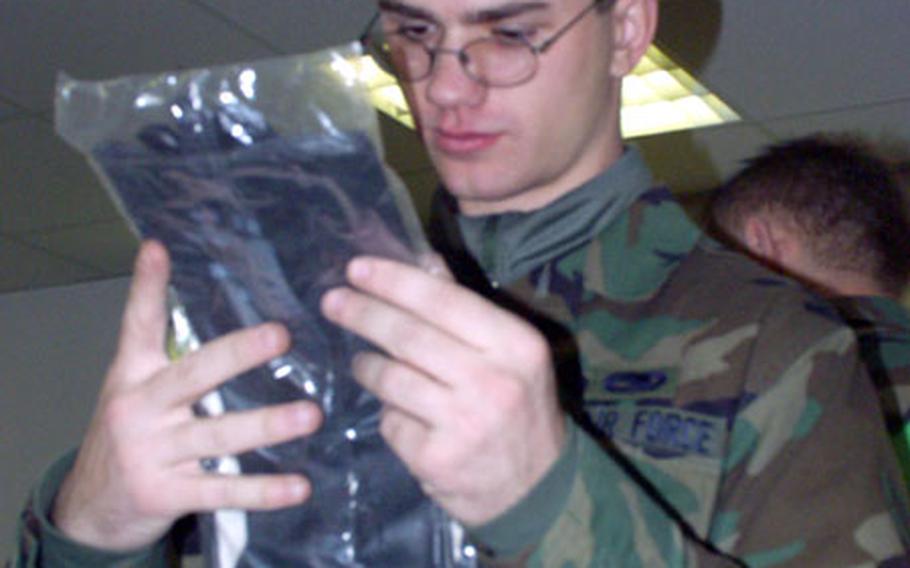 Airman 1st Class Matt Spruit, a 22nd Aircraft Maintenance Unit weapons technician scrutinizes the rubber gloves for his chemical warfare suit carefully. Any holes or leaks in the gear could prove deadly for the troops, warned chemical warfare specialists on Friday. The team of airmen from Spangdahlem Air Base, Germany, took a full range of protection against chemical and biological warfare attacks for their deployment to the U.S. Central Command area of operations.