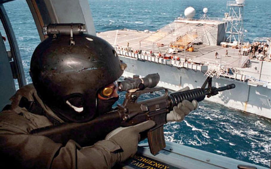 U.S. Navy Lt. Kevin McVadon from Great Falls, Virginia, assigned to Sea Air Land (SEAL) Team Eight, covers his squad from an SH-60 helicopter during a Helicopter Visit, Board, Search and Seizure (HVBSS) exercise on board Commander Sixth Fleet Command ship USS LaSalle (AGF 3) May 20, 1996.