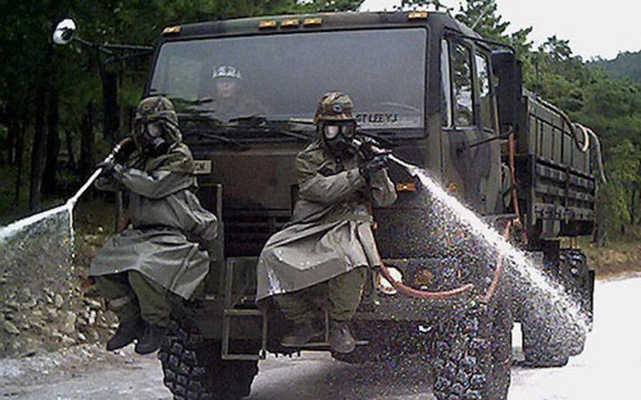 KATUSA soldiers of the U.S. Army's 23rd Chemical Battalion practice chemical decontamination of terrain, at Camp Carroll in Waegwan, South Korea.