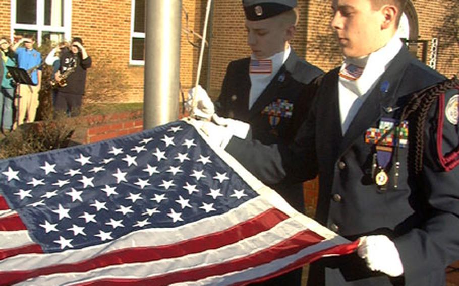 Trey Vickroy, right, and Scott Millard, cadets with the Air Force JROTC at Lakenheath High School, prepare to raise a flag Monday at Lakenheath Middle School on RAF Feltwell, England. The flag was flown above the Pentagon on the first anniversary of the terrorist attacks of September 2001.