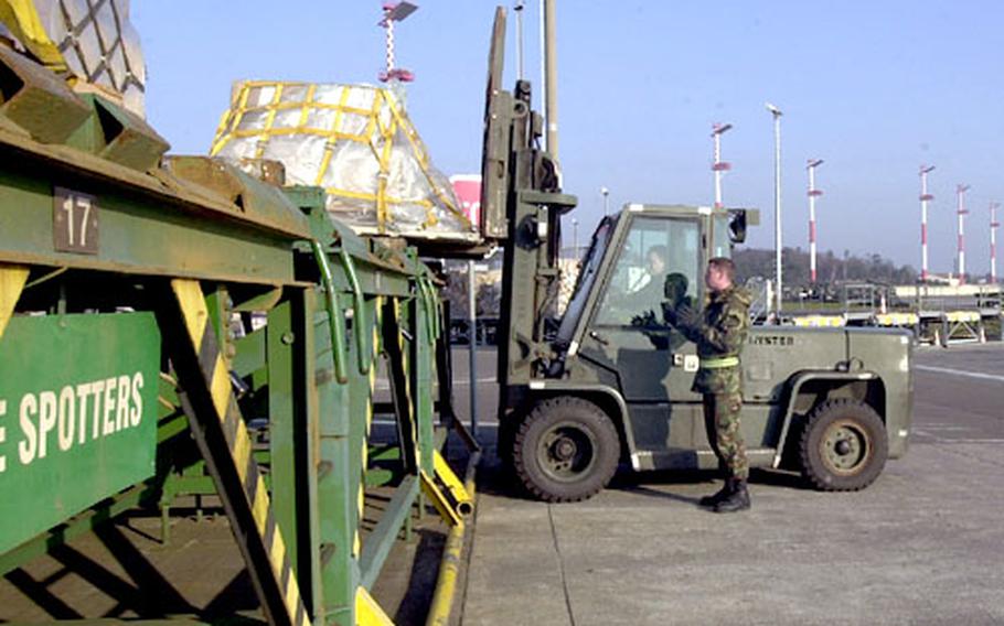 Senior Airman Paul Franklin of the 723rd Air Mobility Squadron at Ramstein Air Base, Germany, directs Staff Sgt. Matthew Huffman as he loads equipment for transportation to a cargo aircraft. The Ramstein flight line has remained busy over the past year, according to wing officials, and the end is nowhere in sight.
