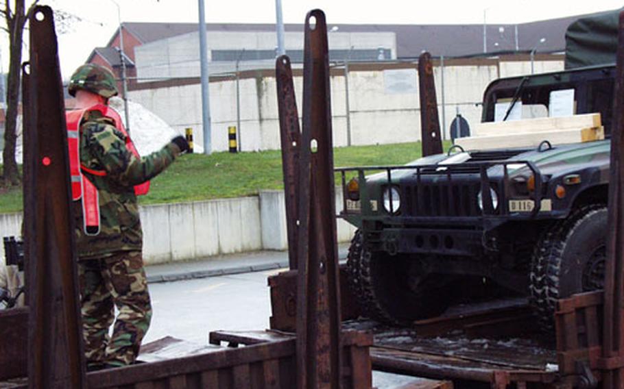A 17th Signal Battalion soldier guides a Humvee aboard a troop transport train at the Harvey Barracks railhead in Kitzingen, Germany. The unit is one of several called up last weekend for deployment to an unknown destination in the Middle East.