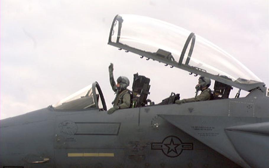 Lt. Col. Jay Silveria, commander of the 492nd Fighter Squadron at RAF Lakenheath, England, signals for his squadron's jets to fire up the engines Friday to begin a deployment to Portugal. Behind him is Capt. Mike Dunyak, the weapons system operator.