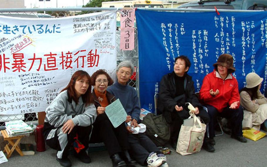 Anti-war protesters are staging a nine-day sit-in in front of the U.S. Consulate in Urasoe (pictured in background).
