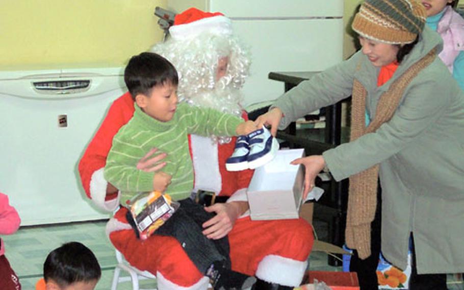 1st Lt. Ben Bartlett, an F-16 pilot, plays Santa Claus on Christmas Day at the Kae Chong Orphangage near Kunsan Air Base. Airmen donated about $10,000 during the holidays to help area orphanages.