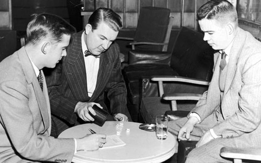 Bill Mauldin, right, plays a parlor game with other journalist at the Tokyo Correspondents' Club in 1952.