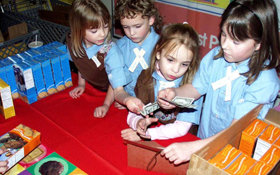 From left, Morgan Ford, Michelle Haynie, Rachel Green and Carolyn Haynie sell boxes and boxes of cookies Tuesday night from a table set up inside the Aviano base exchange complex in Italy.