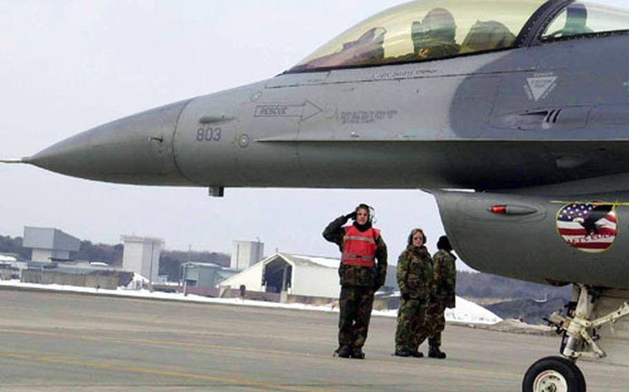 Senior Airman Sean Rafferty, an F-16 crew chief, salutes a Misawa F-16 pilot at the conclusion of the end of runway inspection at Misawa Air Base, Japan.