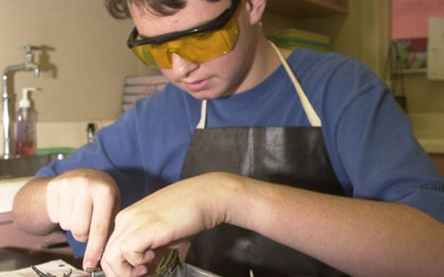 Michael Flynn McKenzie pins down a frog&#39;s leg during a science class dissection at Lester Middle School.