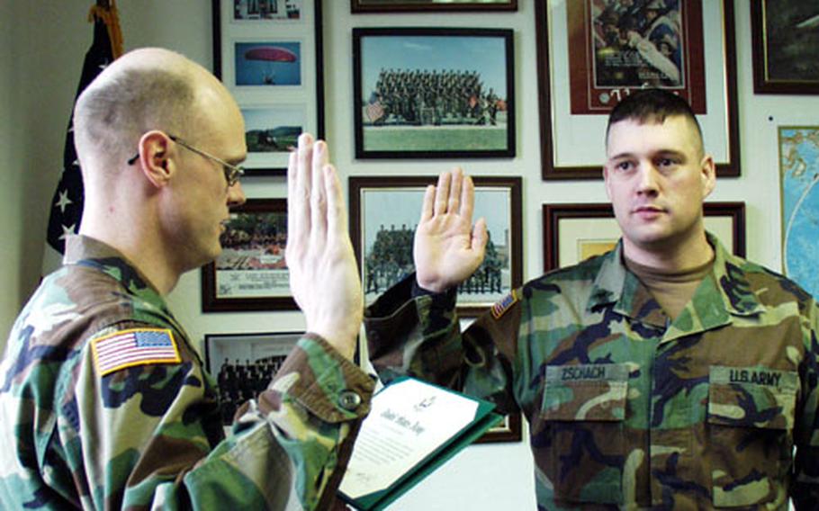 Sgt. Dean Zschach (right) of the 1st Infantry Division's headquarters company is re-enlisted by Capt. Robbin Halstead at Leighton Barracks in Würzburg, Germany. Zschach, 32, had to re-enlist for three years instead of two because of new "retention moderation" policies designed to combat recent overmanning in the Army.