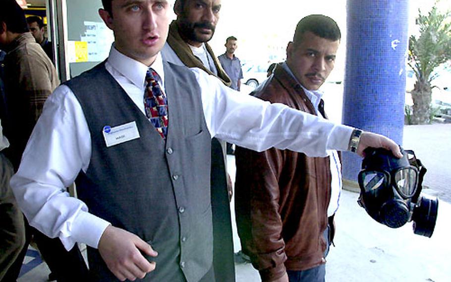 Hadi Hanjour, a clerk at a Kuwait City electronics store, demonstrates a Chinese-made gas mask that retails for 25 Kuwaiti dinars (around $75 U.S.)