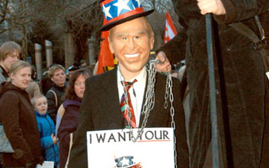 Two anti-war protesters, dressed-up as George Bush and the Grim Reaper, wait for a protest march to begin in Frankfurt.