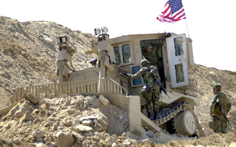 Crewmembers from the 94th Engineer Support Battalion trade places in one of the new 400-horsepower D9 bulldozers.