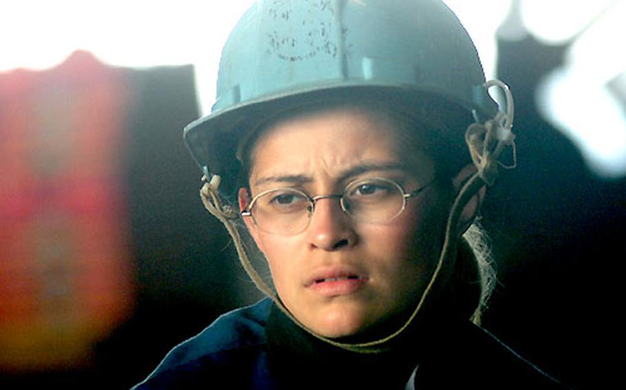 Seaman Jenny Loaiza concentrates as she holds the telephone line during an underway replenishment,