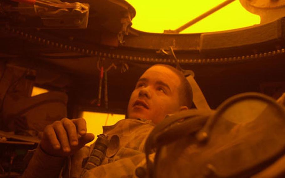 Pfc. Brian Bollan watches the eerie red light caused by a midday dust storm outside As Samawah, Iraq.