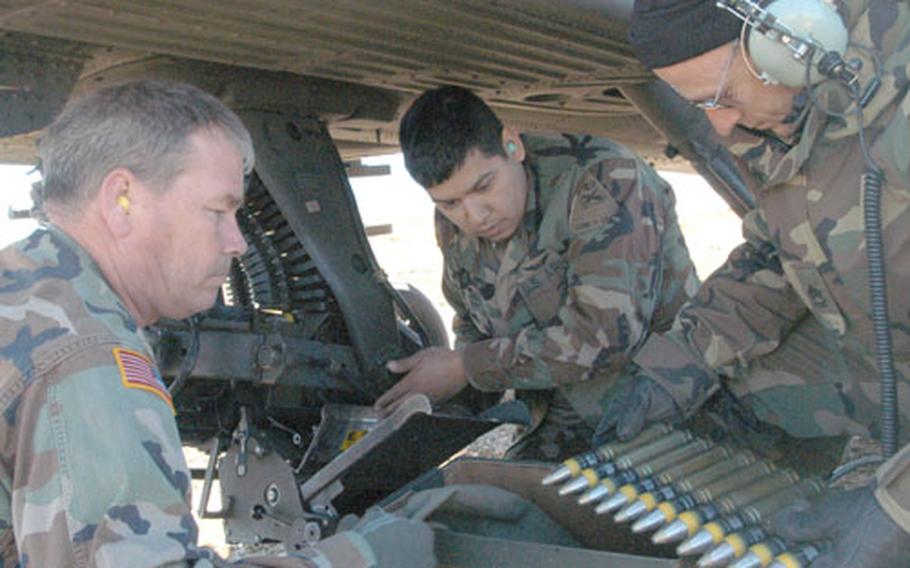 Sgt. John Armstrong, left to right, Sgt. Ramiro Trevino, and Sgt. 1st Class Ric Tinney, all of 1st Battalion, 149th Aviation Regiment, load live rounds into Apache 30 mm gun after practice rounds were used to harmonize the aim and weapons system at an exercise at Glamoc Range, Bosnia and Herzegovina on Wednesday.