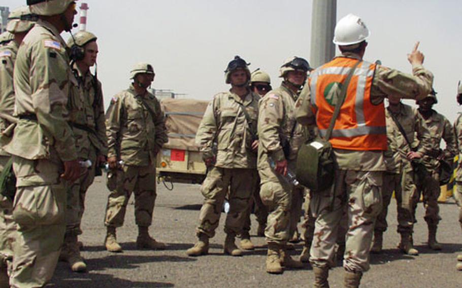Army Capt. Bill Clayson, center, explains on Sunday to soldiers from the 4th Infantry Division how they will get their equipment out of the port. Clayson is one of roughly 70 soldiers from the 1184th Transportation Terminal Battalion, an Army reserve unit from Mobile, Ala., which is coordinating the off-loading of ships bringing equipment into Kuwait.