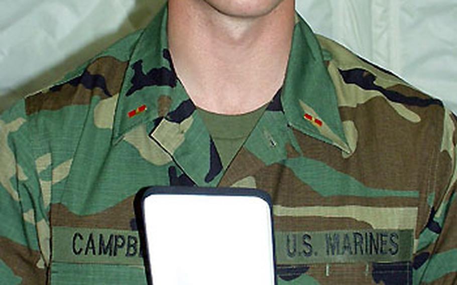 Marine Warrant Officer Chris Campbell holds the Purple Heart he was given after being wounded in Nasiriyah, Iraq, on March 26.