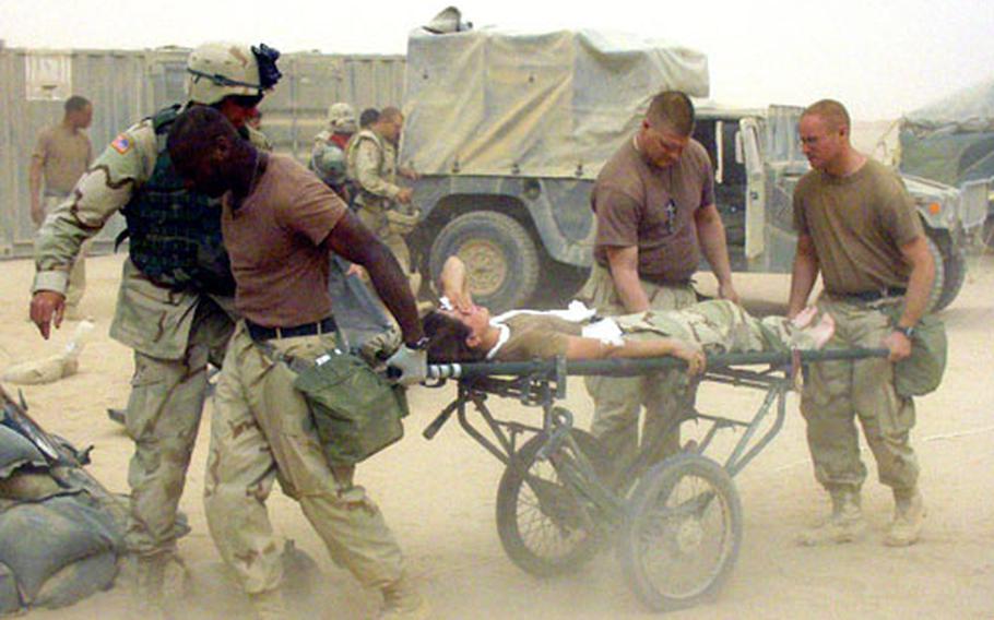 Medics wheel an injured soldier, just unloaded from a Black Hawk medevac helicopter, into the 212th MASH during a sandstorm earlier this week.