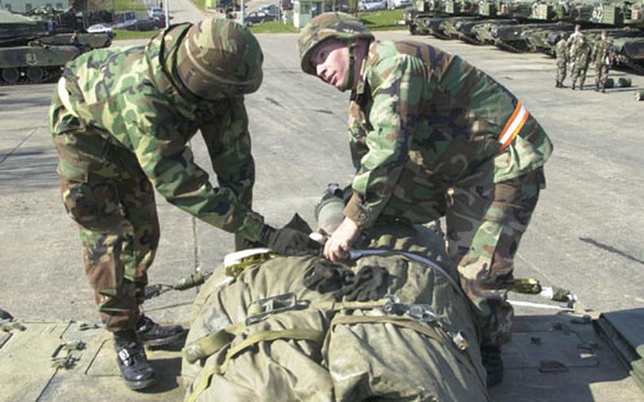 Staff Sgt. Kirk Pryka, right, a Bradley tank commander, confers with his loader, Pfc. Mark Carter. The soldiers are with the 1st Battalion, 35th Armor Regiment of the 1st Armored Division, which is deploying to the war in Iraq.