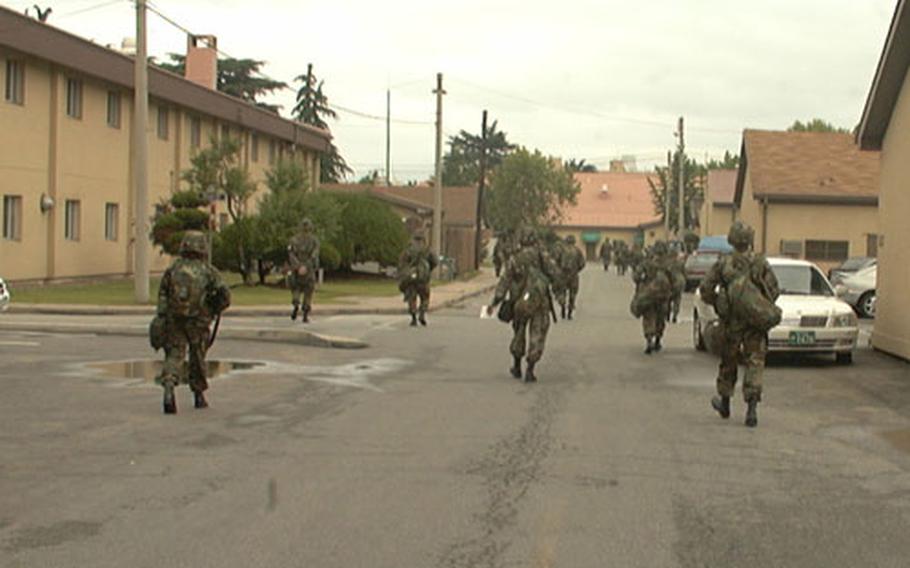 Logistics soldiers of Army's 20th Support Group move along street at Camp Henry in Taegu, South Korea last May during training session in techniques of base defense. Unit leaders say events in Iraq show how important such battle-focused training is for logistics troops.
