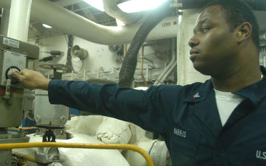 Petty Officer 3rd Class Earnest Harris, 21, a machinist's mate from Littleton, N.C., speeds up the generator in the No. 4 main machinery room on Saturday evening on the USS Kitty Hawk. He said he is looking forward to some quite as the carrier prepares to return to Japan.