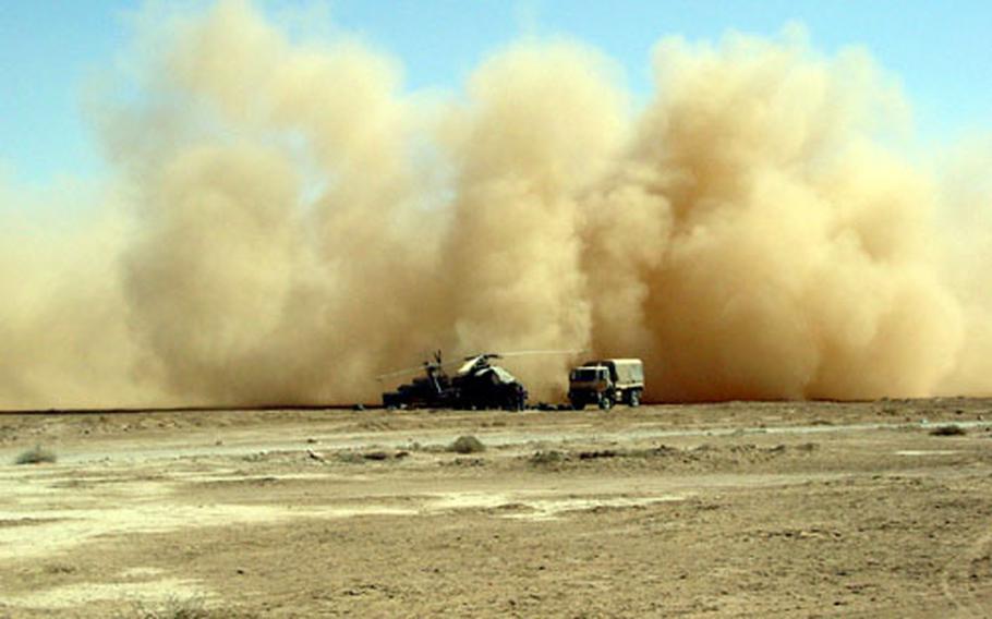 An AH-64A Apache from the 2nd Squadron, 6th Cavalry Regiment, leaves an enormous cloud of dust after landing at a desert airstrip in central Iraq.