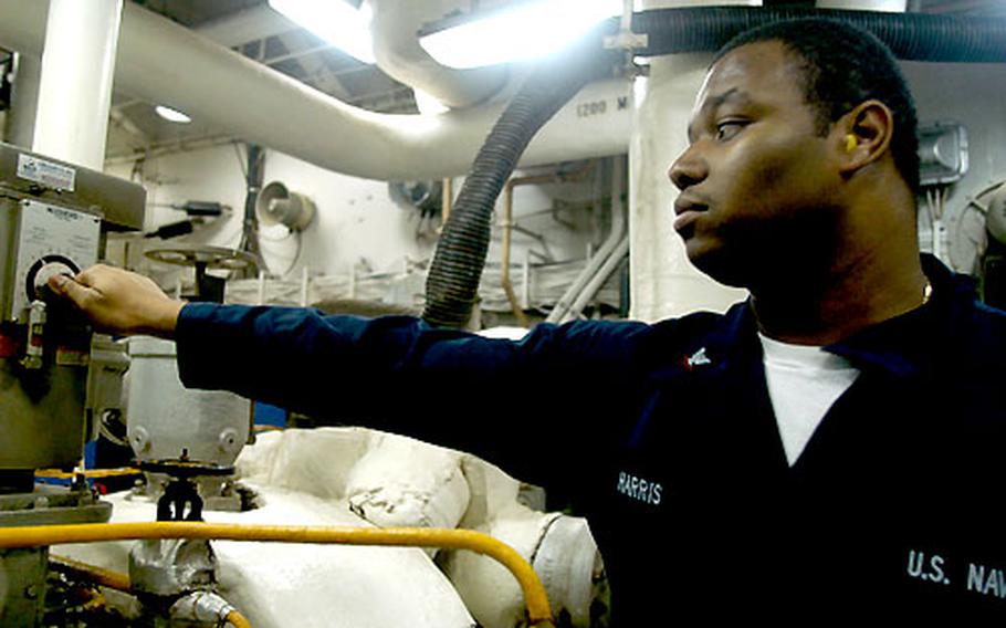 Petty Officer 3rd Class Earnest Harris, 21, a machinist's mate from Littleton, N.C., speeds up the generator in the No. 4 main machinery room on the USS Kitty Hawk Saturday evening.