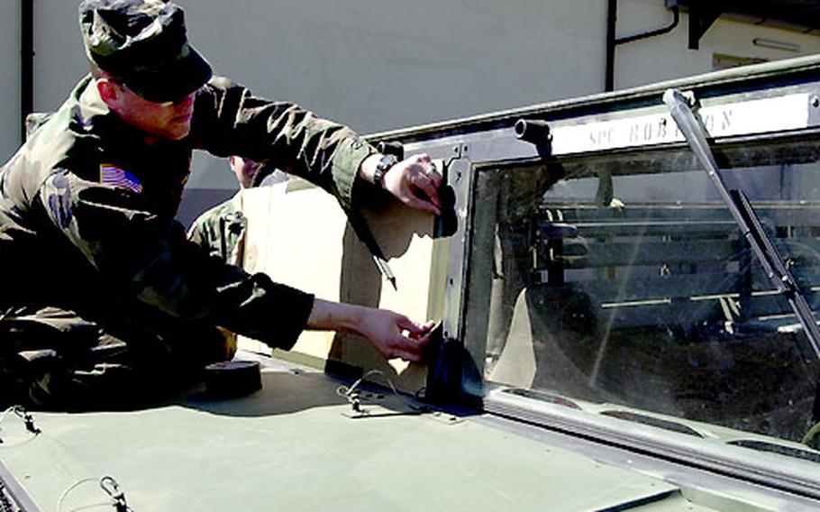 In an action repeated thousands of times at Baumholder, Spc. Tim Robinson protects a vehicle’s windscreen by taping on a piece of cardboard scavenged by Baumholder logistics workers. Robinson’s headquarters company — the 4th Battalion, 27th Field Artillery Regiment, Division Artillery — is preparing to deploy to Iraq with the 1st Armored Division.