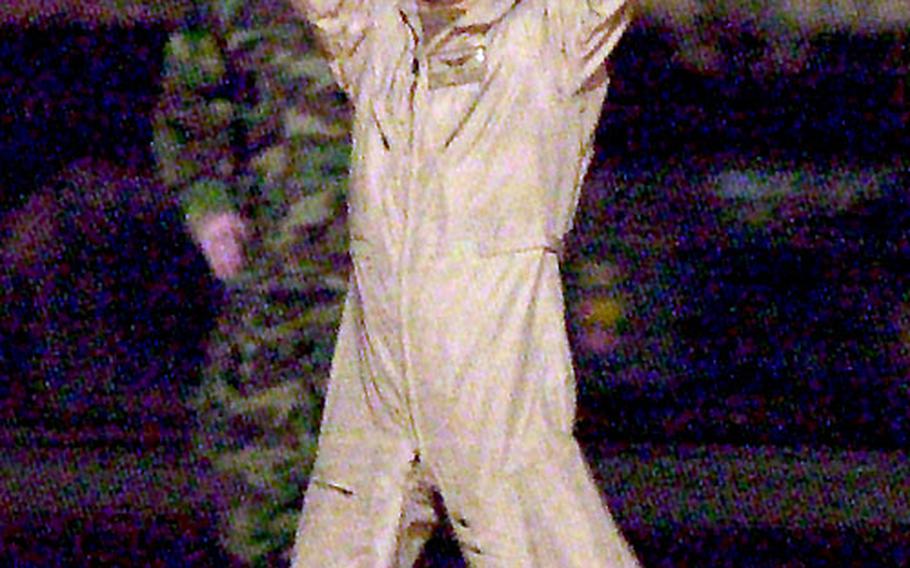 Chief Warrant Officer David S. Williams of the 1st Battalion, 227th Aviation Regiment, a former POW who was rescued Sunady in Iraq, waves to the media after landing at Ramstein Air Base, Germany, Wednesday night.