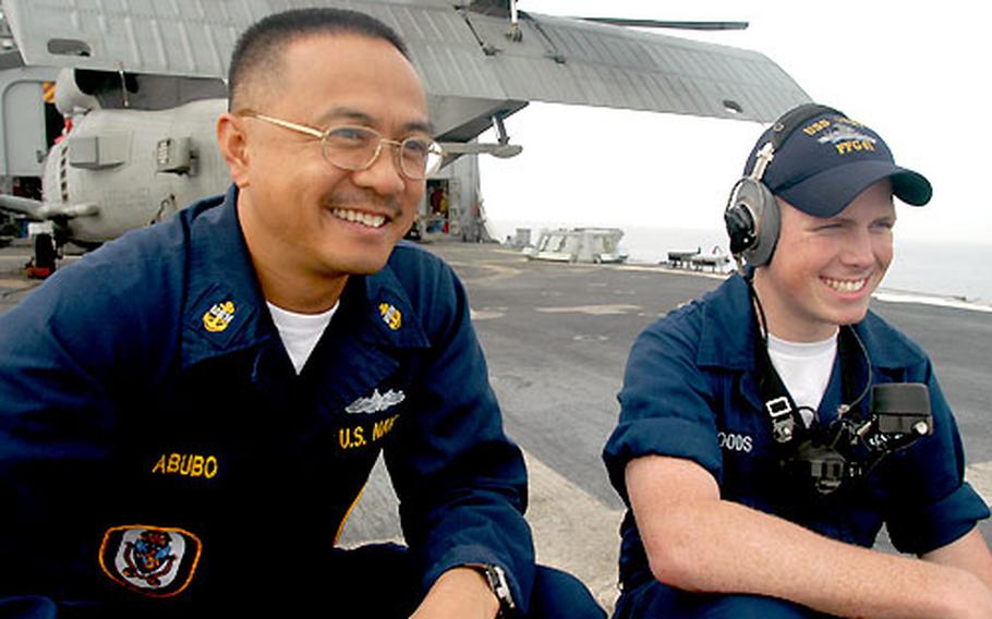 Sailors on the USS Gary say they enjoy the camaraderie of a small crew; there are no strangers on a ship of 250 sailors. Chief Petty Officer Jeff Abubo, 40, a master-at-arms from Baguio, Philippines, chats with Seaman Kent Woods, 21, standing lookout on the fantail near a helicopter.