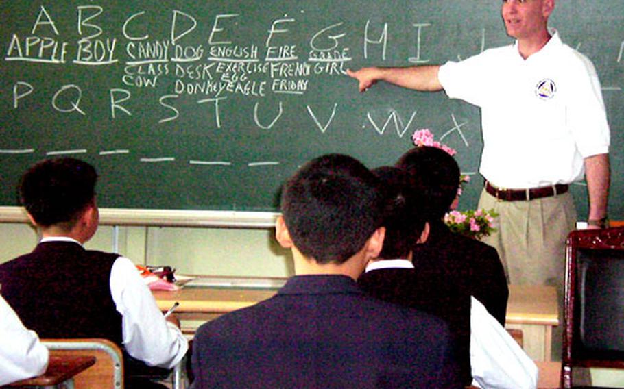 Army Lt. Col. Conrad Munster goes over the alphabet during a recent Saturday afternoon English class at Kyongsan Boys Middle School in South Korea. Munster is a member of 19th Theater Support Command in Taegu, which has “adopted” the school as part of a U.S. military drive to forge good relations between U.S. forces and the South Korean public.