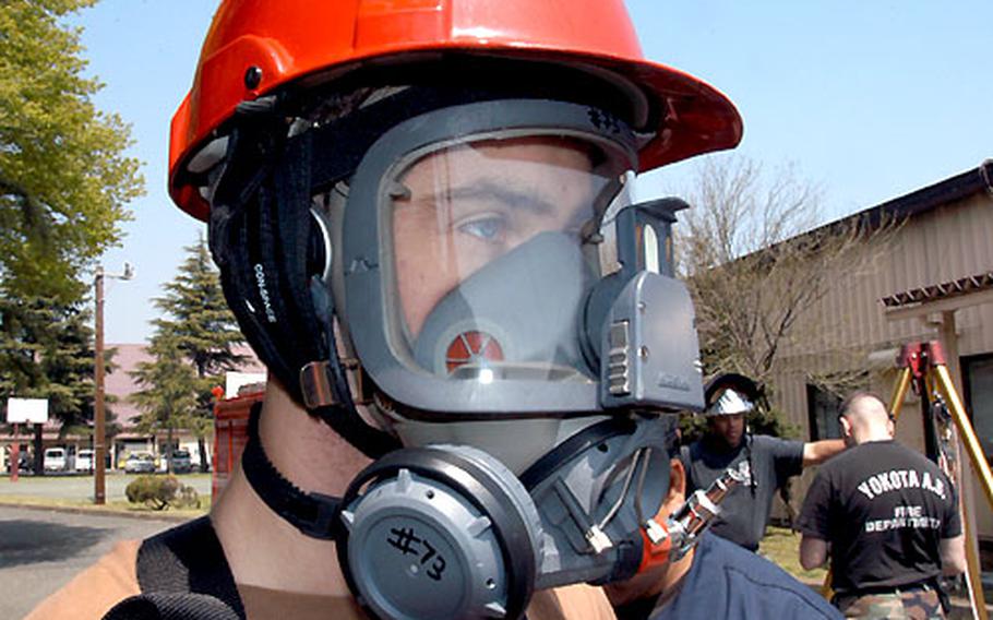 Airman 1st Class Ben Hosbein, a firefighter at Yokota Air Base, was fitted with a fully-encapsulated ventilator mask before descending into a manhole during an earthquake exercise Thursday at Yokota.