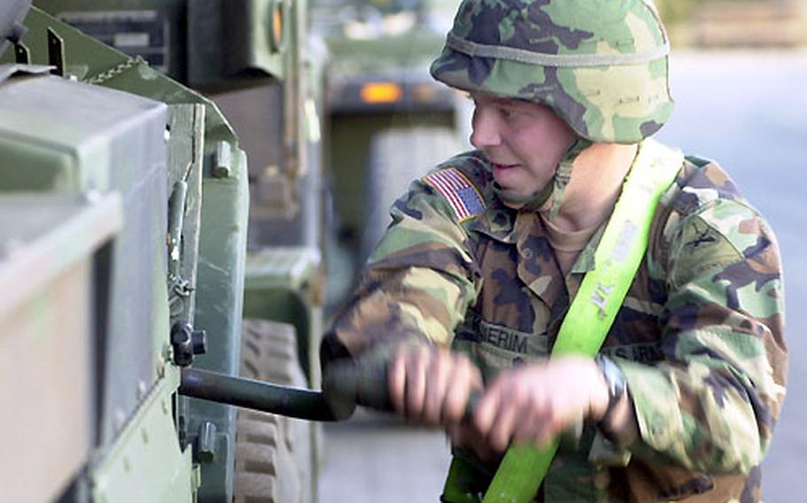 1st Armor Division soldier Spc. Jason Knierim "drops the landing legs" on a fuel truck at a barge loading site in Mannheim, Germany.