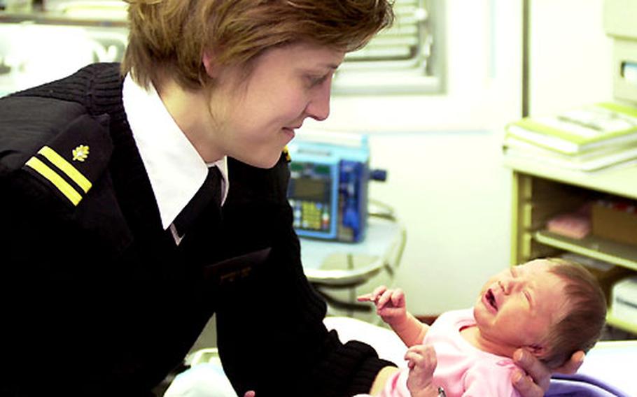 At Yokosuka Naval Hospital, Lt. Mari Nasin prepares to give Sophie Sakura Remington, born April 7th, a post-natal examination.
