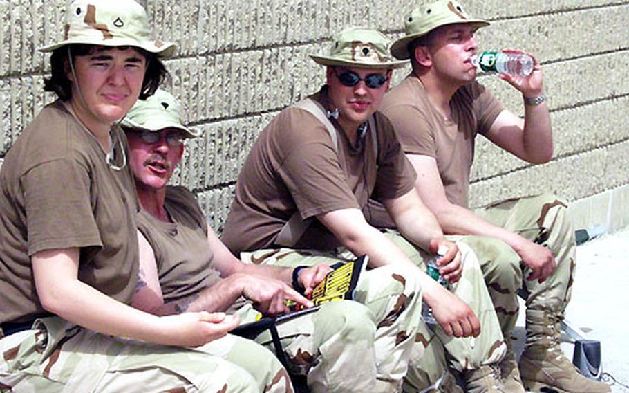 With nothing to do but wait for their trucks to arrive, transportation soldiers from the National Guard in Maine pass the time waiting and trying to cope with the heat Sunday at Camp Arifjan, Kuwait.