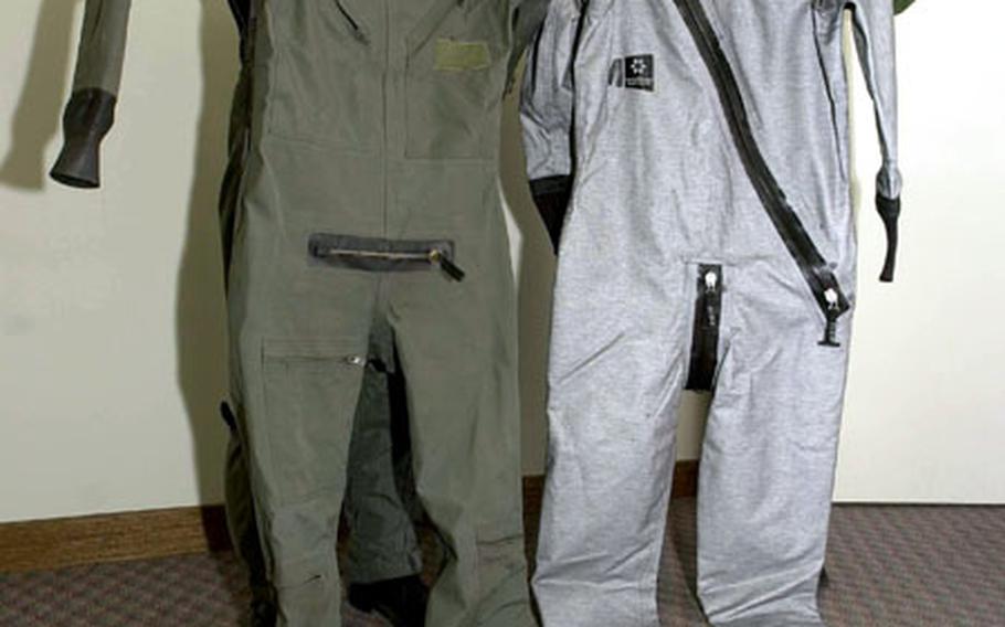 Lt. Col. Luke Grossman, left, holds the current version of an anti-exposure suit pilots to protect them in icy ocean waters if forced to eject from their aircraft. It may be replaced by the silver model held by Master Sgt. William Ryan, life support superintendent for the 35th Operational Support Squadron. F-16 pilots from Misawa Air Base, Japan, could start flight testing the new suits as soon as next week.
