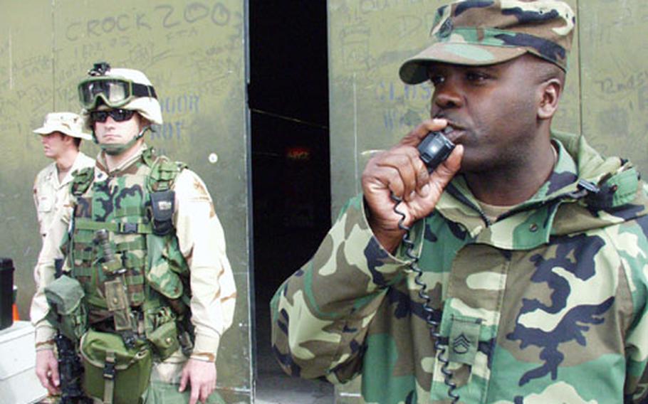 On the radio, Staff Sgt. Edwidge Patterson, a 1st Infantry Division solider temporarily assigned to the deployment center, directs troops on where to drop their bags Monday in Kaiserslautern, Germany.