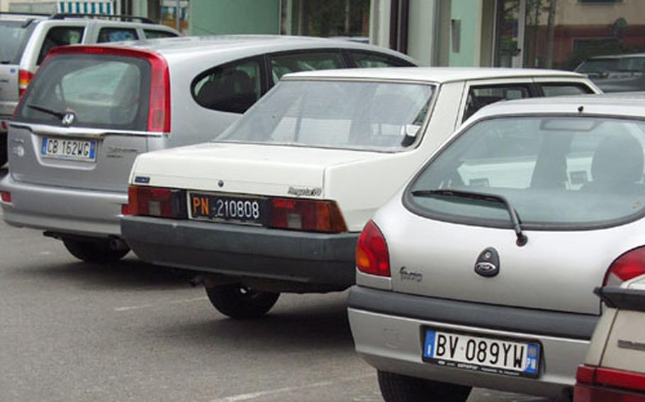 Are these cars parked at a shopping center in Aviano, Italy, owned by Americans or Italians? Thanks to recent efforts by military officials, it's pretty hard to tell. Most soldiers stationed in Italy are now driving with Italian plates on their vehicles. And hundreds of airmen will soon join them.