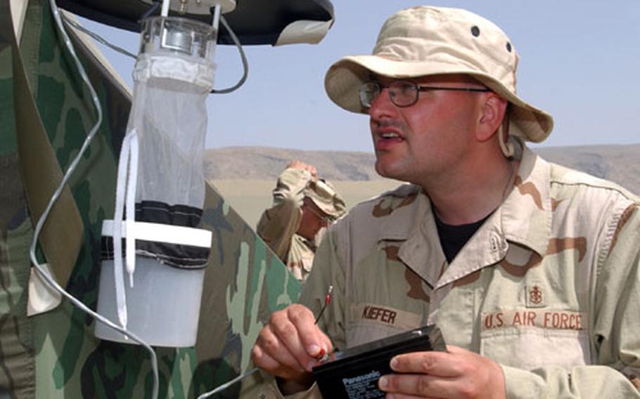 U.S. Air Force Tech. Sgt Heinz Kiefer of the 86th Expeditionary Contingency Response Group, Environmental Medicine Flight, sets up a mosquito trap near work tents at the edge of Bashur airfield in northern Iraq last week.