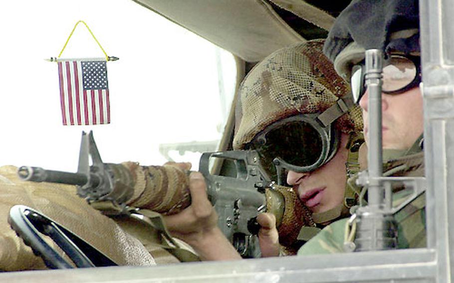 A Marine from 2nd Battalion, 23rd Marines watches for enemy movement from the cab of a seven-ton truck while convoying north through southern Iraq.