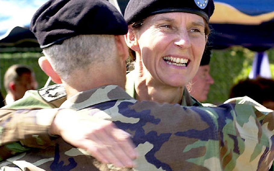 Col. Rhonda Cornum, right, gets a congratulatory hug from outgoing commander Col. David Rubenstein on Friday after assuming command of the Landstuhl Regional Medical Center.