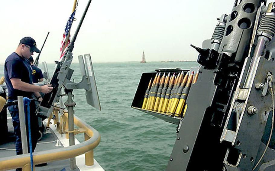 Petty Officer 3rd Class Jason Schmitz, 22, of Jacksonville, NC., prepares a .50 caliber machine gun onboard the Coast Guard cutter Baranof in the Persian Gulf.