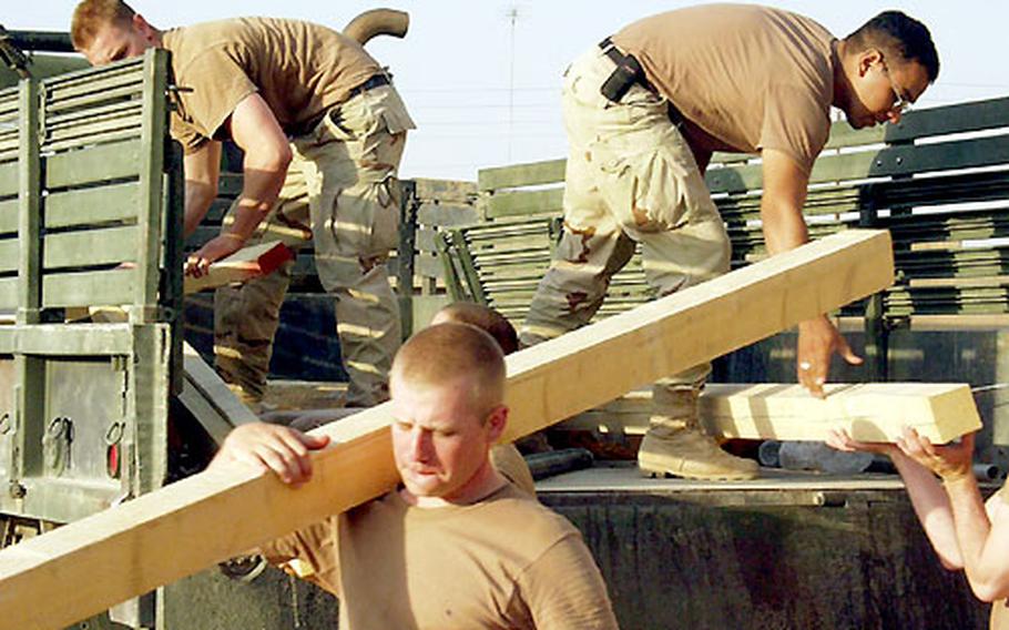 Soldiers assigned to Company A, 1st Battalion, 508th Infantry Regiment keep busy with tasks such as getting material to make their camps more secure. Some of this lumber was going to be used to build an outhouse.
