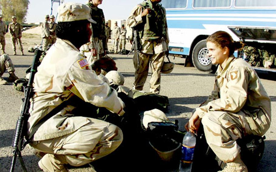 At Qayyarah West Airfield in Iraq, Spc. Jessica Middleton, from Charleston, N.C., left, and Pfc. Cristal Schorn, from Schaumberg, Ill., both with the 1st Brigade of the 101st Airborne Division, prepare Monday to board the bus for northern Iraq.