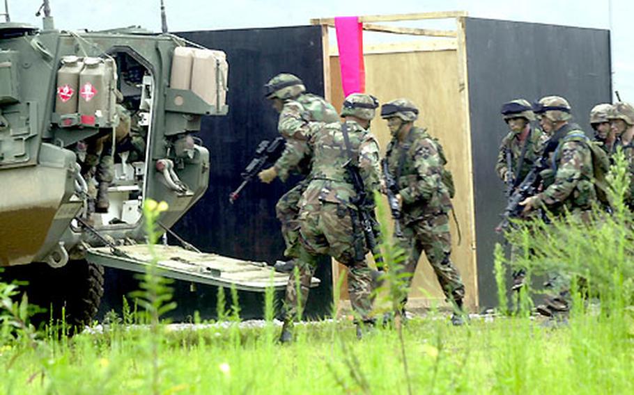 Infantrymen climb back inside a Stryker armored personnel carrier after assaulting a target during a live-fire exercise Monday at Rodriguez Range.